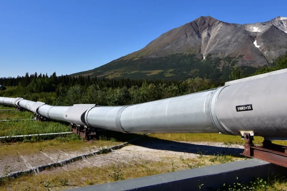 Ground level view of Alaska Pipeline oil pipeline near Prudhoe Bay, Alaska with bare mountains in background.